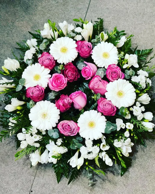 Pink rose and white gerbera sympathy wreath on grey
